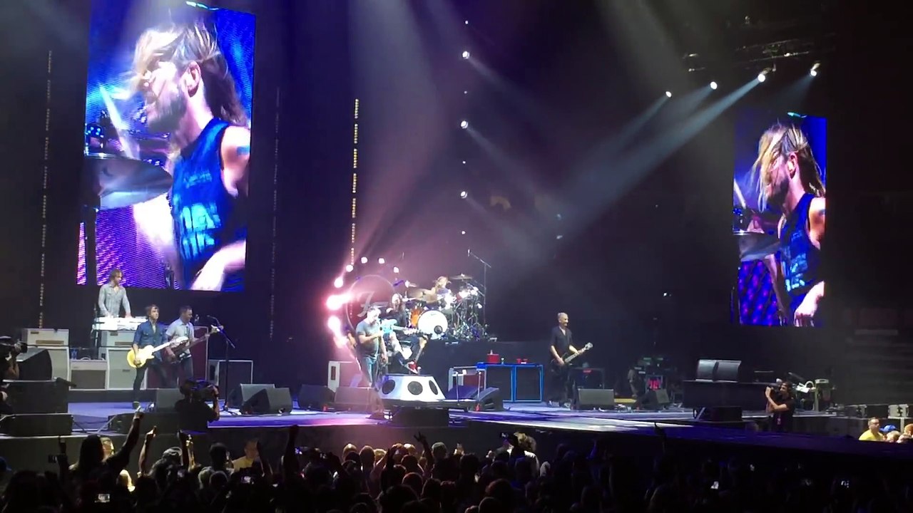 Un fan monte sur scène chanter "Tom Sawyer" de Rush lors d'un concert des Foo Fighters