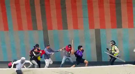 Momento en el que manifestantes agredieron con palos a un PNB