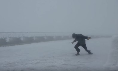 Un homme se bat contre des vents à 160 km/h