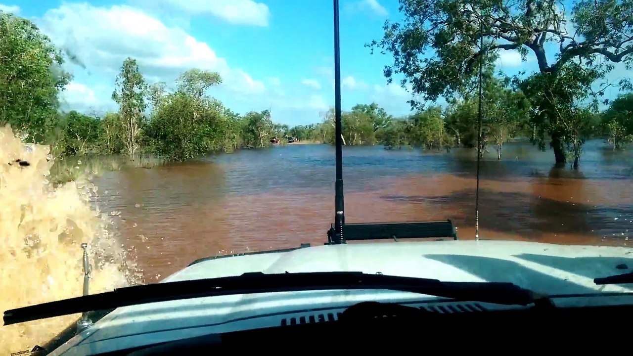 Il conduit son 4x4 Land Rover à travers le lit d'une rivière