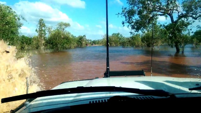 Il conduit son 4x4 Land Rover à travers le lit d'une rivière