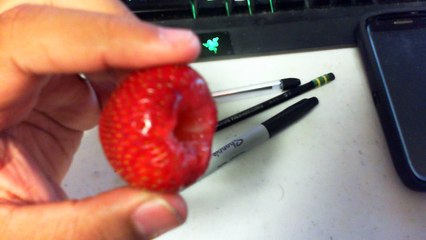 Finger Being Inserted Into a Strawberry