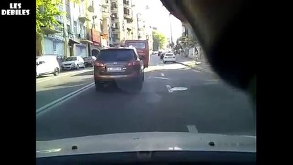 Motard se prend la portière d'une voiture