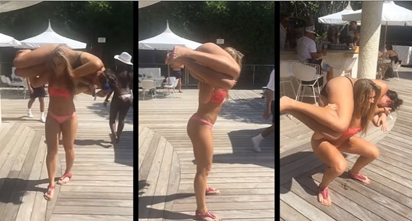 Une jolie fille fait des squats au bord de la piscine