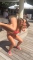 Une jolie fille fait des squats au bord de la piscine