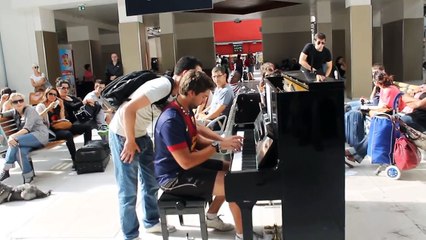 A musician is playing on a public piano. This man walks up and blows everyone away.