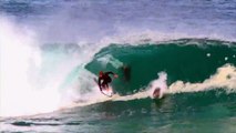 Le surfeur Soli Baileys prend une vague avec un dauphin