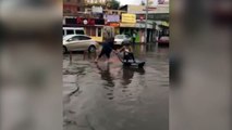 على طريقة المصريين..كازخستانى يستغل غرق الشوارع بمياه الأمطار لكسب قوته