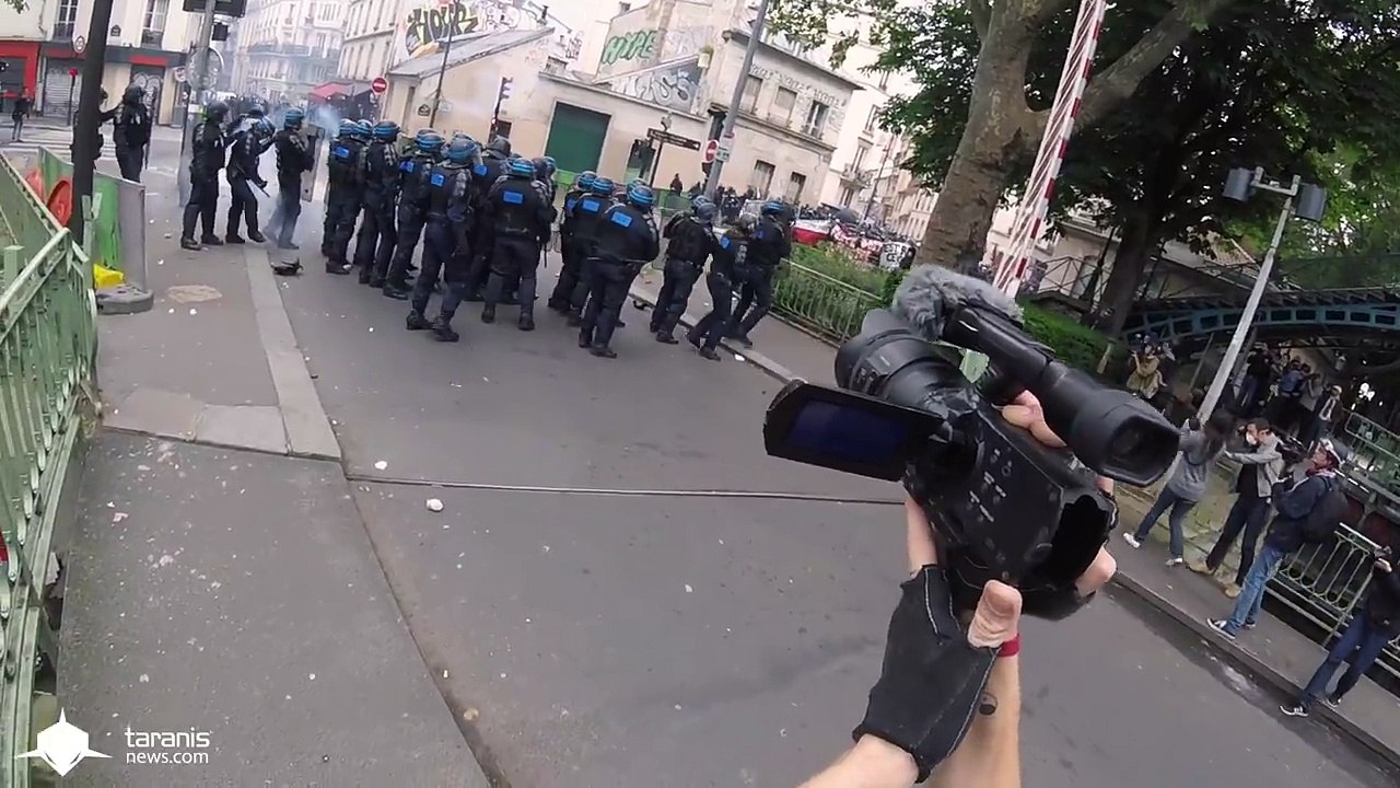 un CRS joue au foot avec un manifestant
