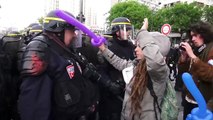 Un policier éclate le ballon d'une manifestante au visage, elle simule une blessure