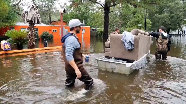 Il transporte un divan en pleine inondation... mais regardez bien qui est sur le divan!