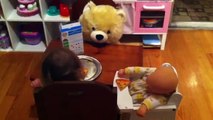 Evie (24 months) feeds baby and plays with her cell phone