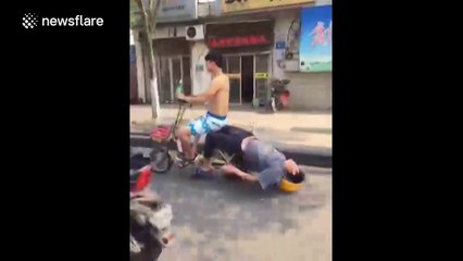 Construction worker sleeps on the back of a moving motorbike