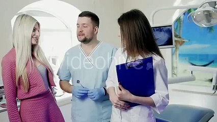 Handsome Doctor and a Patient Dentist With an Assistant Standing