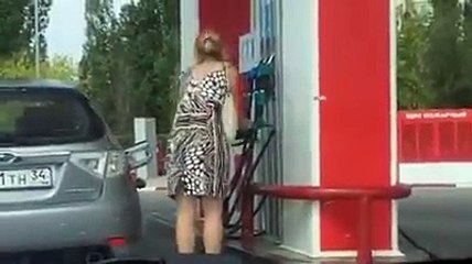 Une femme dans une station essence...