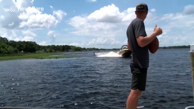 Man catches American football while doing a backflip on a wakeboard