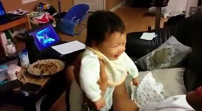 Le papa tient le bébé dans ses bras pendant que la maman filme, mais quand elle voit ça? Elle perd tous ses moyens!