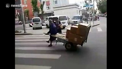 Man cleverly balances handcart for effortless ride