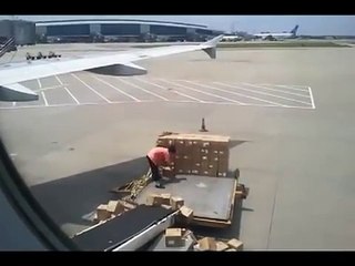 Un employé jette les cartons à côté du chargement de l'avion