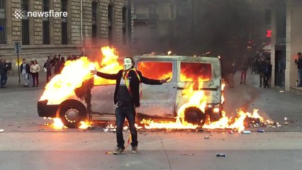 Masked man dances next to van on fire in Paris