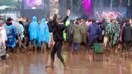 Un fou danse comme un possédé dans la boue pendant un festival