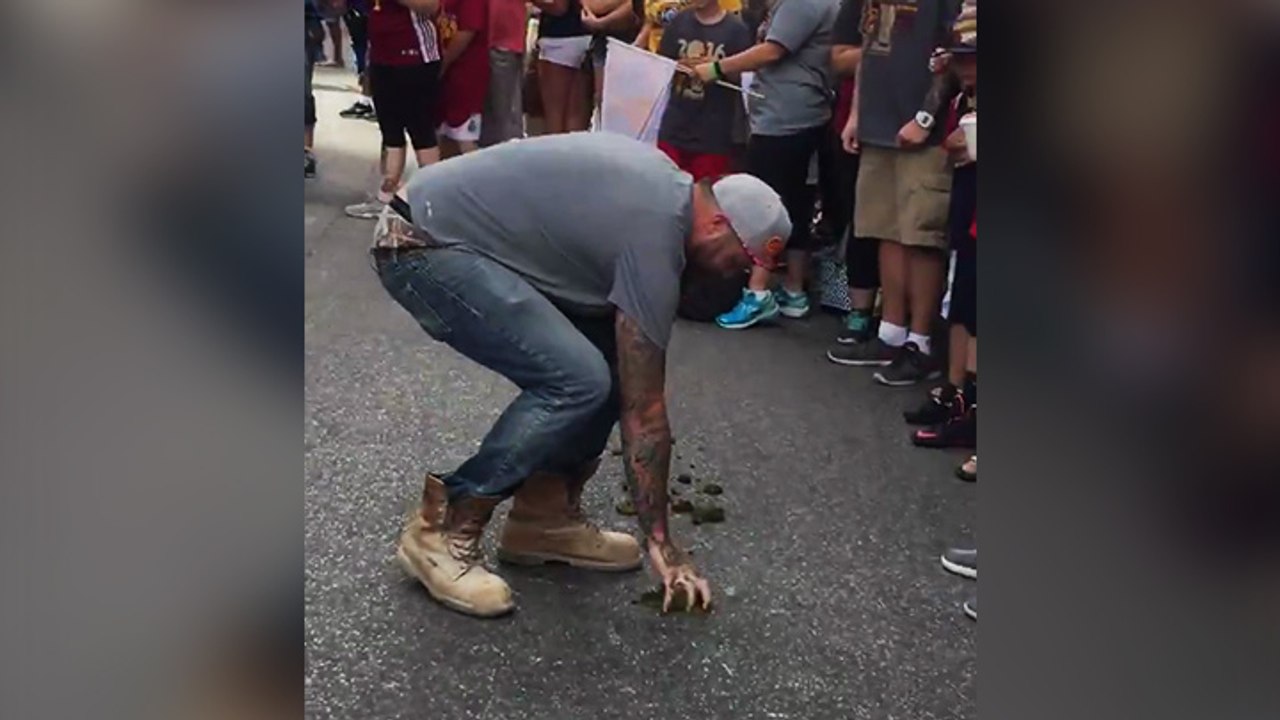 Un supporter des Cavs mange du crottin de cheval pendant la parade