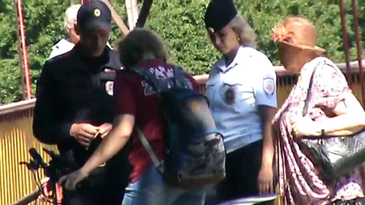 Полицейские сотрудники полиция разговаривают в парке с девушкой