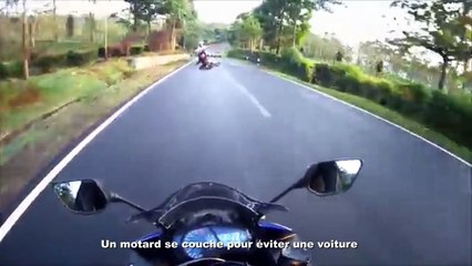 Un motard se couche pour éviter une voiture