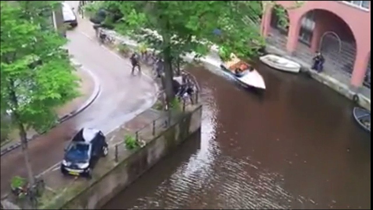 Une Smart se fait éjecter dans un canal à Amsterdam par un Porsche Cayenne