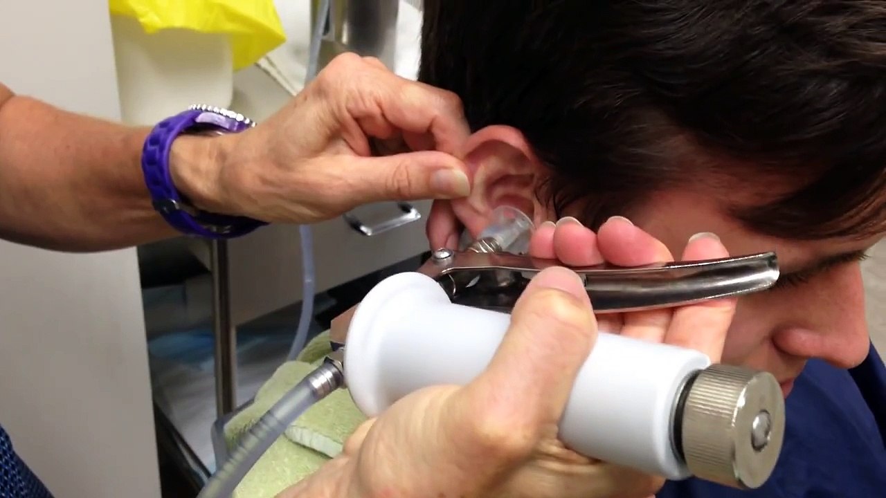 Elle lui injecte de l'eau dans les oreilles... mais ce qui sort de là? OH MON DIEU, j'en frissonne!