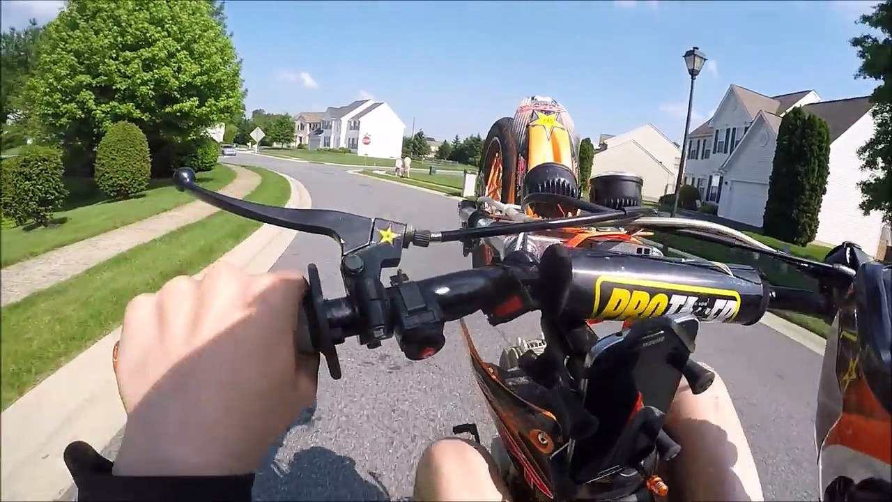 Un motard tente un wheelie devant une jolie fille pour l'impressionner