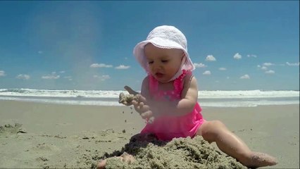 Un bébé surpris par une vague... La tête trop marrante