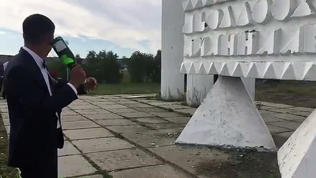 Il jette une bouteille de champagne contre un monument ...