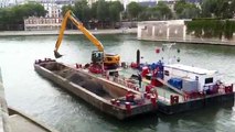 Aux pieds de Notre-Dame de Paris, une grue flottante s'emploie à nettoyer le fond de la Seine