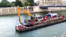Aux pieds de Notre-Dame de Paris, une grue flottante s'emploie à nettoyer le fond de la Seine