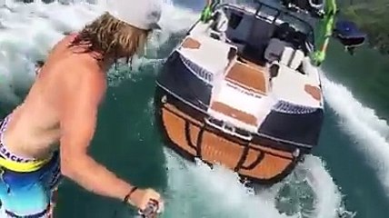 Un surfeur se lance de son bateau en marche alors qu'il est seul dessus