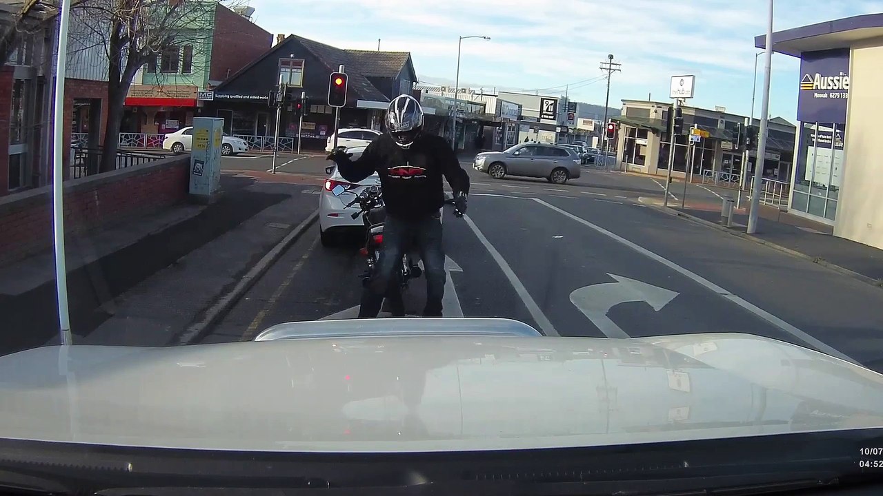 Un motard descend aux feux rouges pour amuser les automobilistes