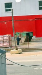 Un ouvrier en colère ramasse du sable.. Enfin il essaie