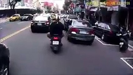 Un motard se prend la porte d'une voiture, mais ce n'est pas tout !
