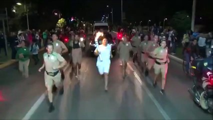 Un homme tente d'éteindre la flamme olympique avec un extincteur