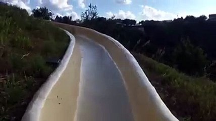 Un homme dérape hors d'un toboggan extérieur et chute