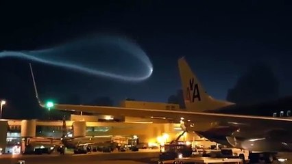 Airport workers' disbelief as 'UFO' trailing blue smoke flies over the runway.