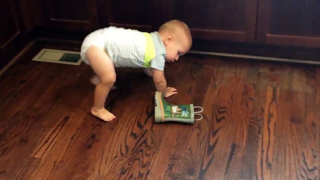 Ce bébé tente tout pour mettre une botte.. Technique de fou