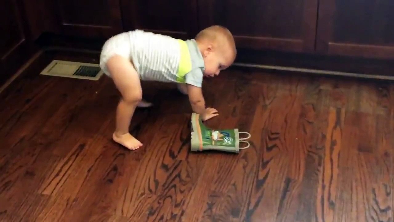 Un adorable bébé galère à enfiler une botte