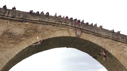Des grimpeurs escaladent un pont sans équipement de sécurité