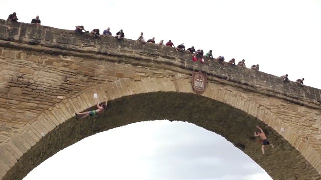 Des grimpeurs escaladent un pont sans équipement de sécurité