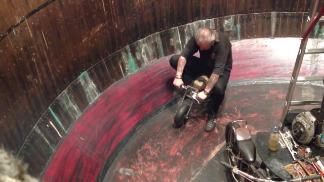 Il escalade en mini moto les parois d'un réservoir cylindrique