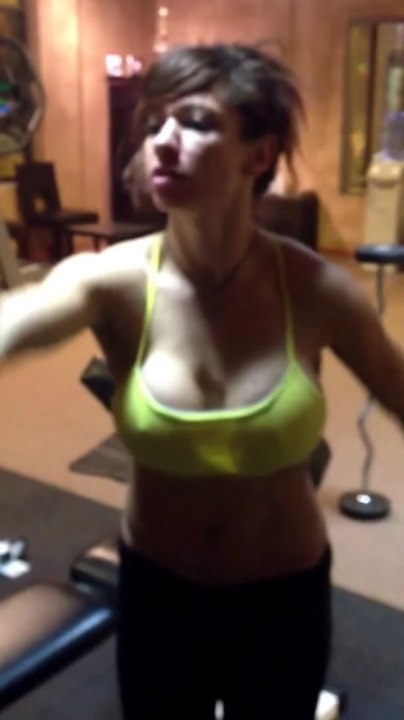 Sexy fitness girl goes up in weight for biceps curl.