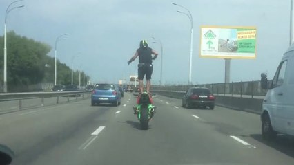 Ce mec se balade debout en moto sur une autoroute