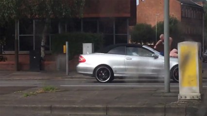 Ce mec tape sur le pare-brise d'une voiture avec ses poings